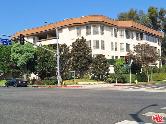 Front view of a multi-story residential building at a street corner.
