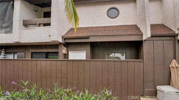 Front view of a two-story residential building with a fenced entrance.
