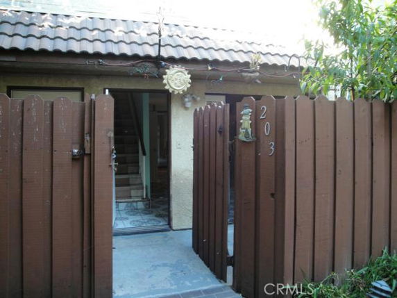 Front view of a house with a wooden fence and tiled roof.