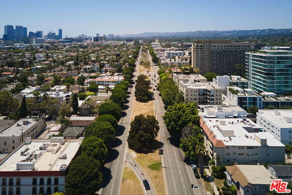 Panoramic view of a cityscape with buildings, roads, and greenery.