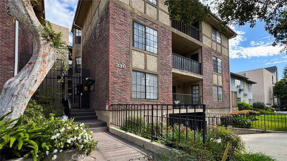 Front view of a multi-story residential building with brick and stucco exterior.