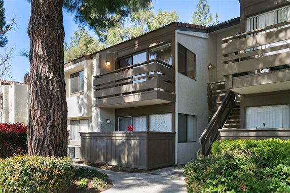 Front view of a multi-story residential building with balconies and large windows.