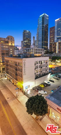 Front view of a multi-story building in a cityscape during evening.