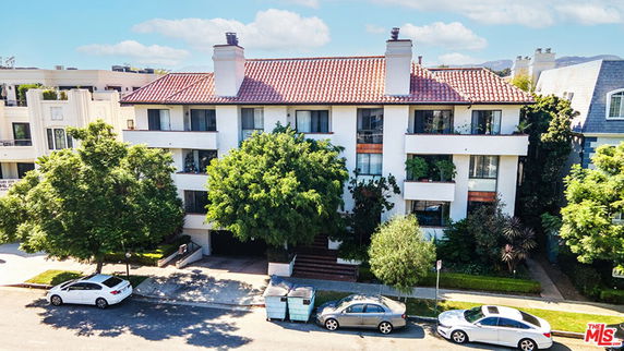 Front view of a multi-story building with a tiled roof and balconies.