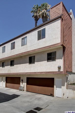 Front view of a multi-story building with large garage doors and windows.