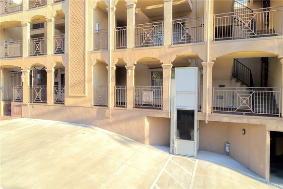 Front view of a multi-story building with columns and balconies.