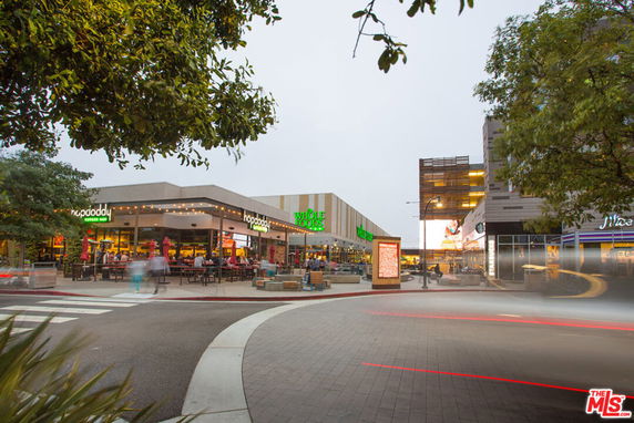 Front view of a commercial shopping area with restaurants and shops.