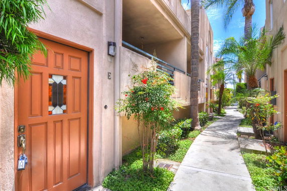 Front view of a building with a brown door and narrow walkway.