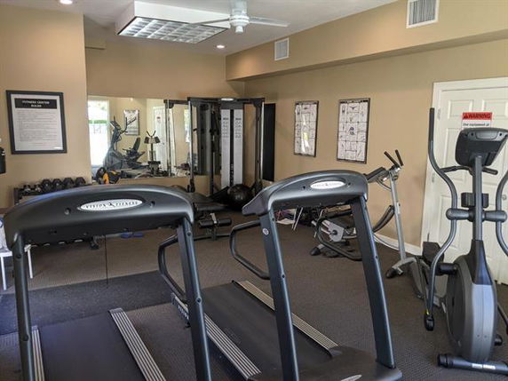 Indoor gym with treadmills, exercise bikes, and other fitness equipment.