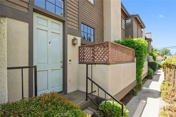 Front view of a multi-story house with a blue door and lattice railing