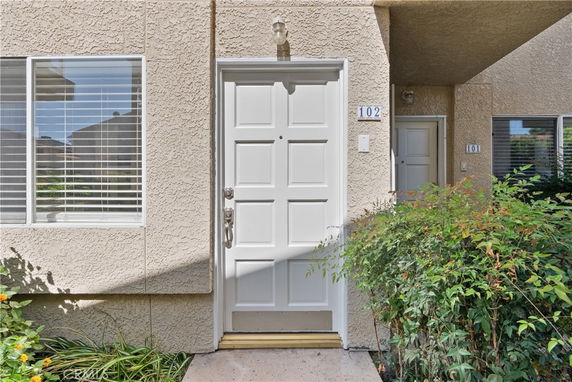Front view of a textured exterior with a white door and window.