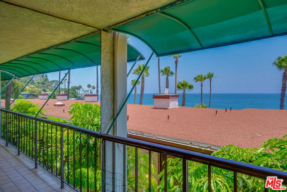 Panoramic view from a balcony overlooking the sea and rooftops.