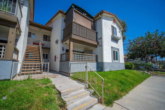Front view of a multi-story residential building with external staircases.