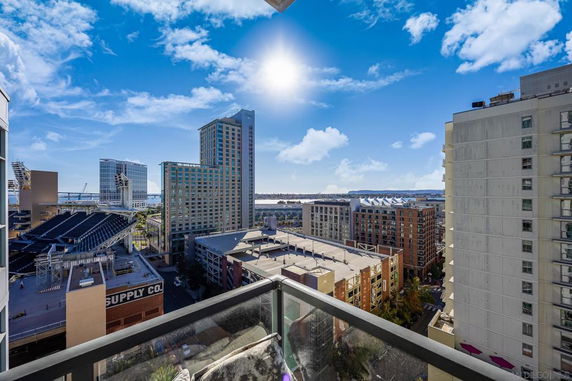 Panoramic view of cityscape from a building with multiple skyscrapers, a stadium, and water in the background.