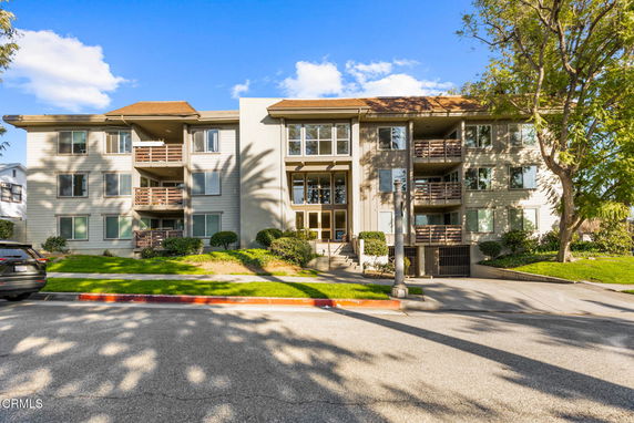 Front view of a three-story apartment building with balconies.