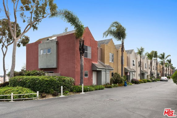 Front view of a row of multi-story houses with colorful facades.