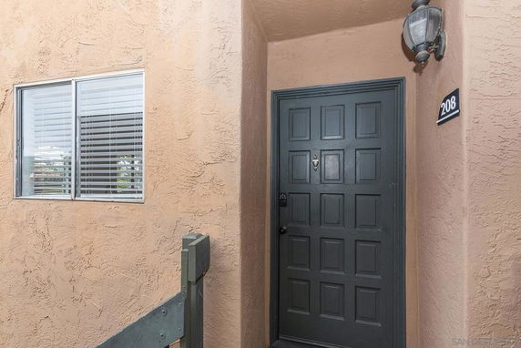 Front view of an entrance door to a building with a window next to it.