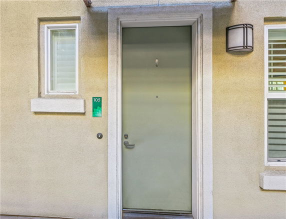 Front view of a building entrance with a green door and a window.
