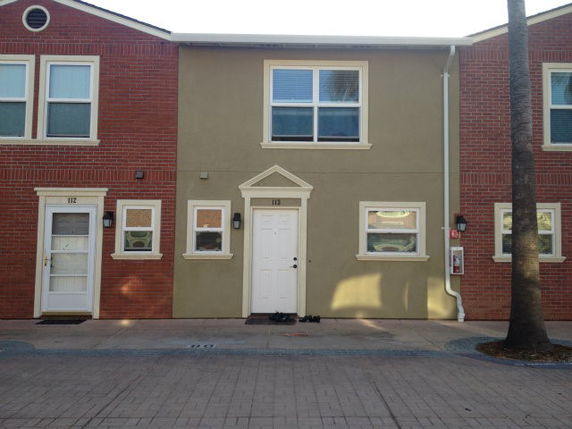 Front view of a two-story townhouse with a central entrance and two windows on each floor.
