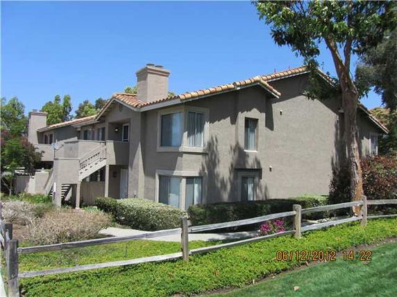 Front view of a two-story building with a tiled roof and exterior staircase.