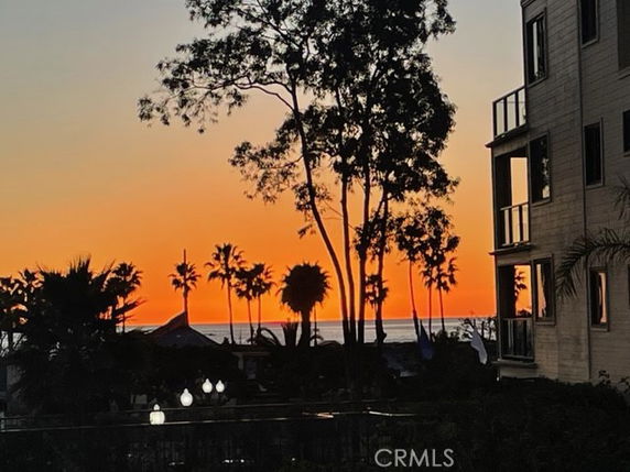 View of surrounding areas with trees against a sunset near a building.
