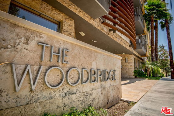 Front view of a building with a stone facade and the name 'The Woodbridge' displayed.