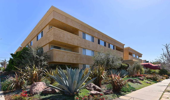 Front view of a multi-story building with a beige exterior and several windows.