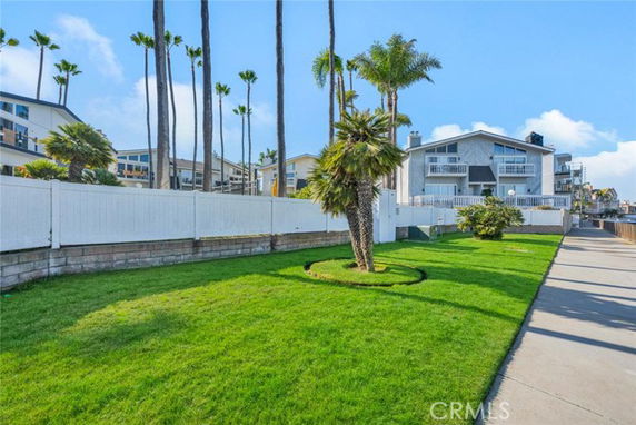 View of multiple houses with balconies and tall palm trees in the surroundings.
