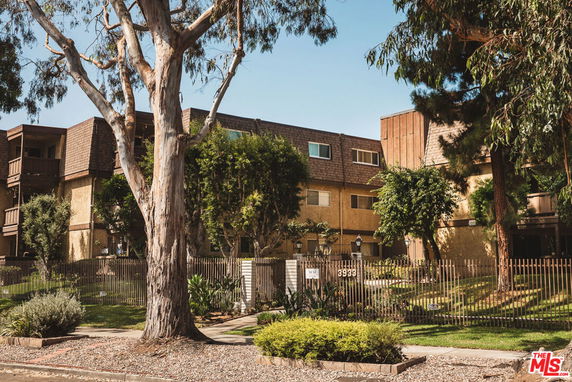 Front view of a multi-story apartment building with a sloped roof and brown exterior.
