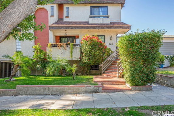 Front view of a two-story house with a staircase leading to the entrance.