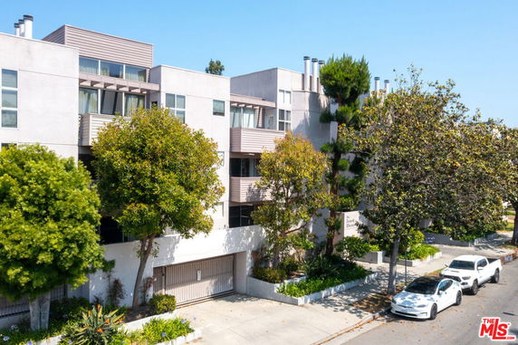 Front view of a multi-story building with balconies and large windows.