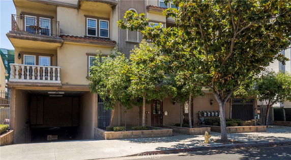 Front view of a multi-story apartment building with balconies.
