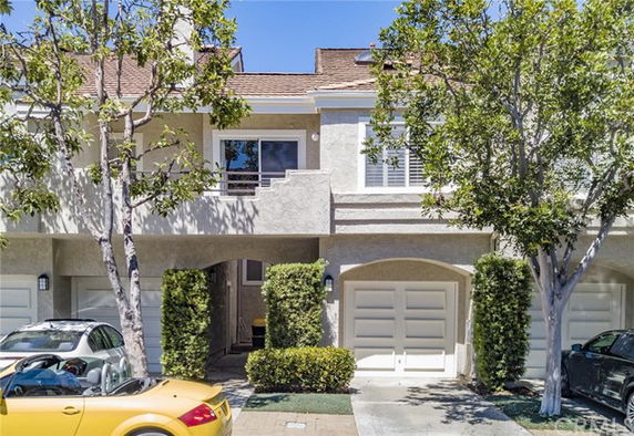 Front view of a two-story house with two garage doors and a small balcony.