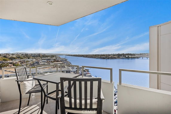 Balcony view of a waterway with docks and cityscape in the distance.