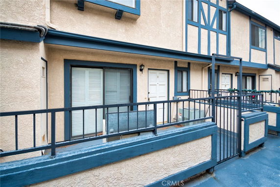 Exterior view of a multi-story building with blue trim and metal railings.