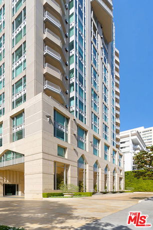 Front view of a high-rise building with multiple balconies and large windows.