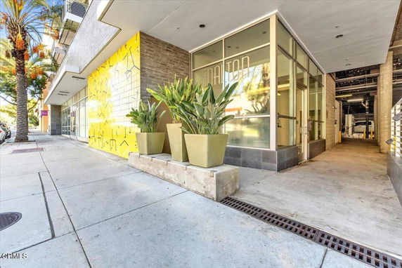 Front view of a modern commercial building with large windows and decorative planters.