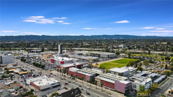 Panoramic view of a cityscape with commercial buildings and distant hills.