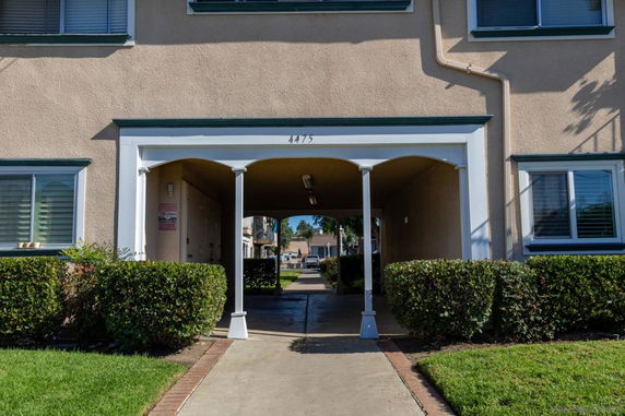 Front view of a building with an archway entrance and multiple windows.