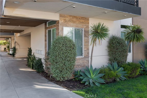 Front view of a modern house with stone accents and greenery.