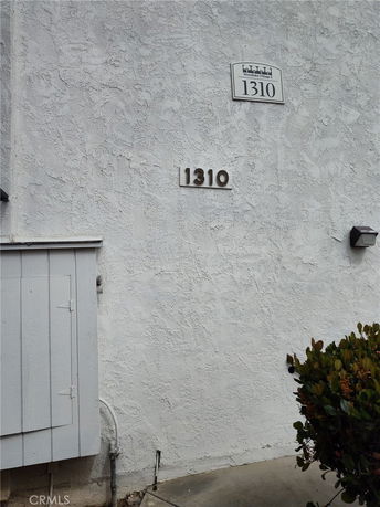 Close-up view of a building's exterior wall with the number 1310 displayed.