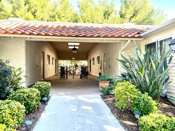 Front view of a house with a covered entrance and red tile roof.