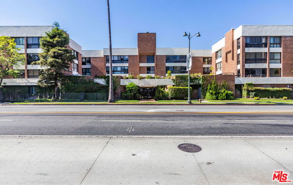 Front view of a multi-story building with a brick facade and modern architectural design.