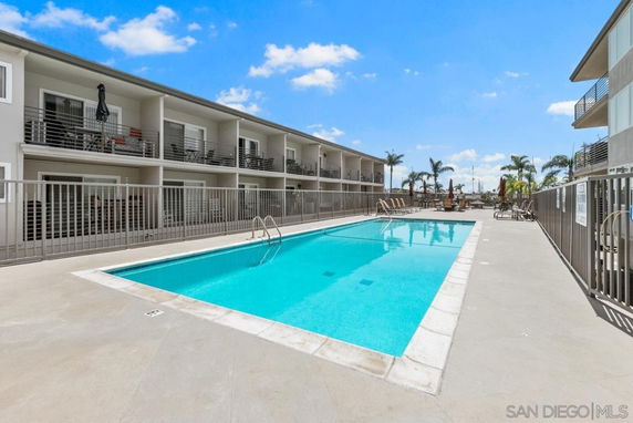 Outdoor swimming pool area with adjacent buildings.