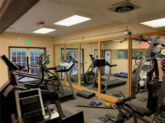 Indoor gym area with exercise equipment and mirrors.