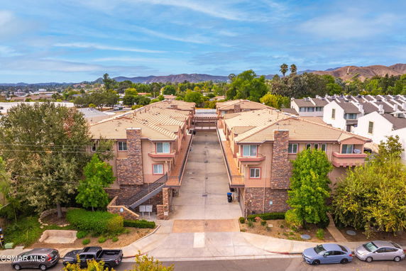 Elevated view of an apartment complex with a central driveway and multiple units.
