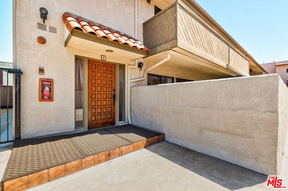 Front view of a building with a wooden door and balcony above.