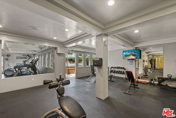 Indoor gym area with fitness equipment and a TV.