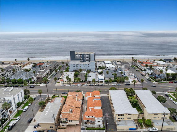 Aerial view of a coastal area with roads, buildings, and ocean in the background.