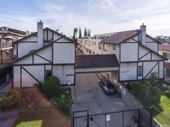 Front view of a building with a gated entrance and Tudor-style architecture.